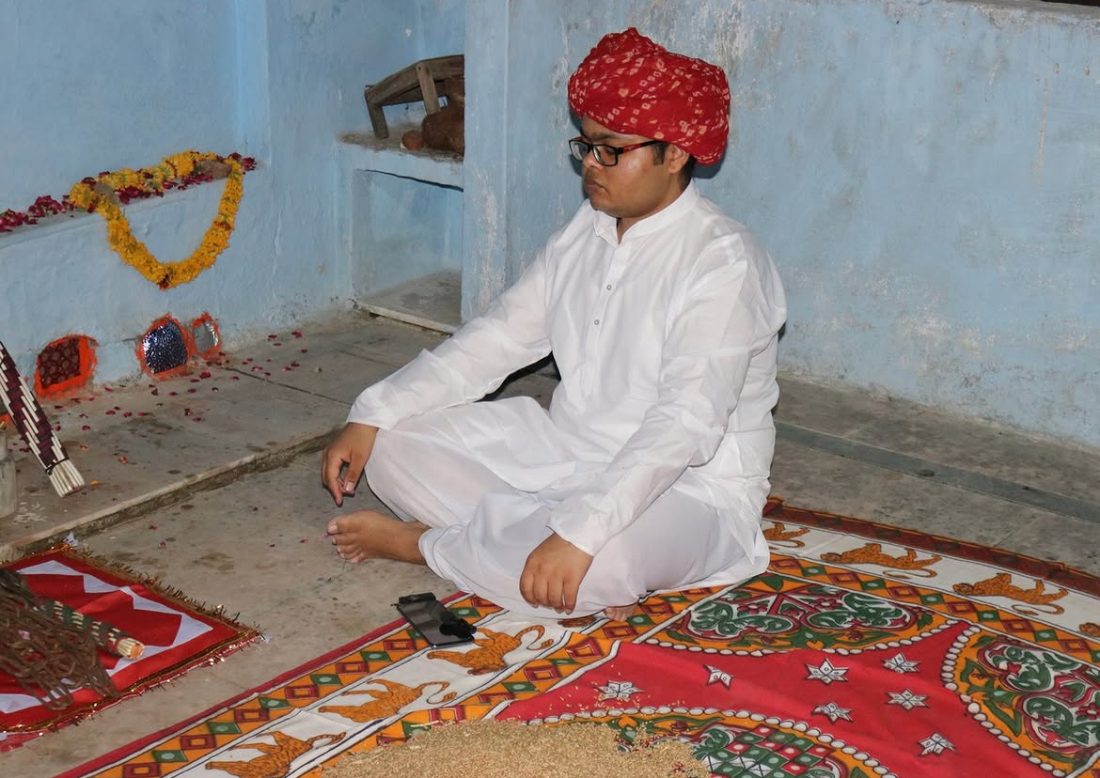Bhaava practice — seated in traditional dress in a shrine